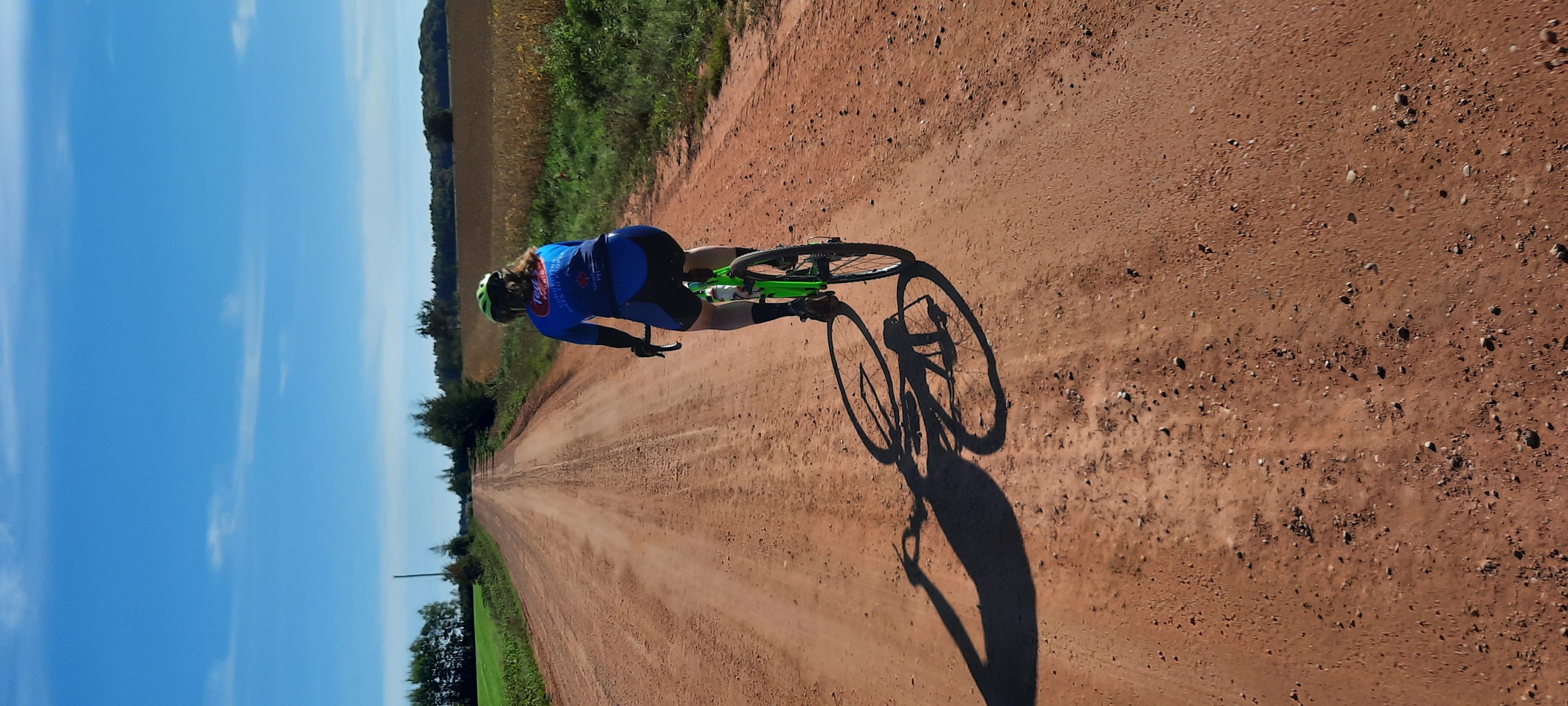 Woman riding on red gravel road